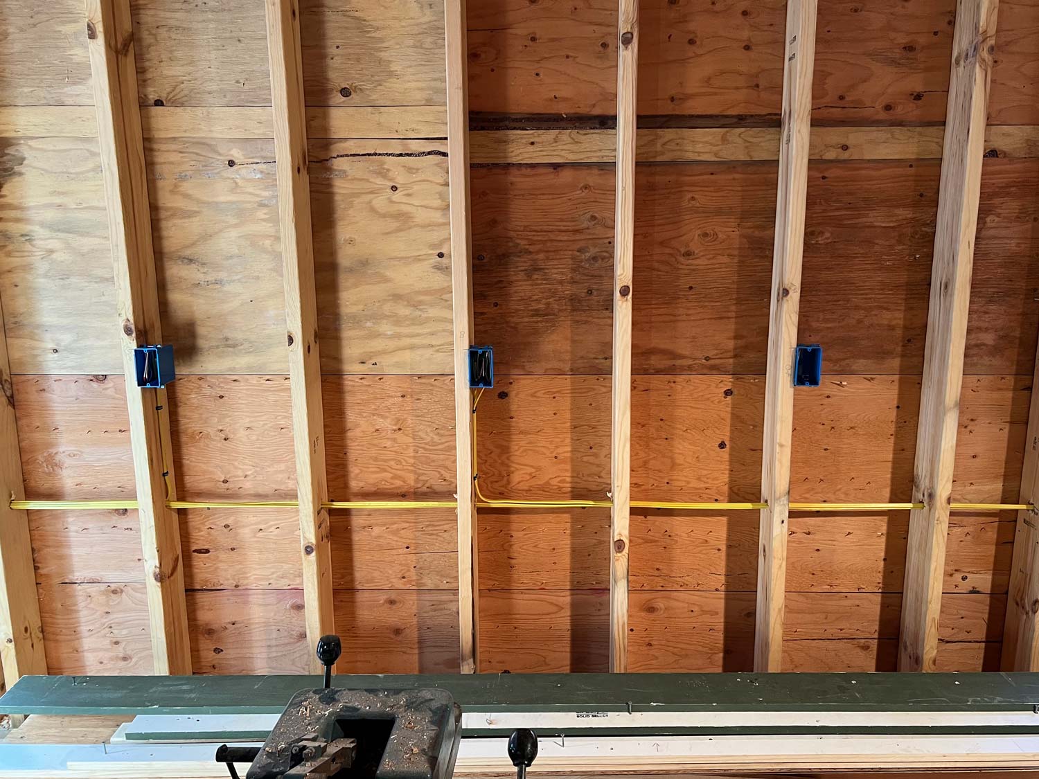 Three outlet boxes and cable stapled to open studs before drywall